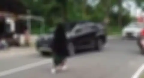 Wanita bercadar terekam kamera video berjalan santai di tengah jalan hingga menimbulkan kemacetan. Polisi ungkap fakta sebenarnya.