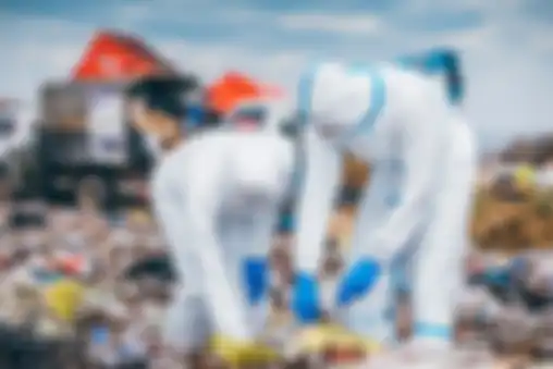 Two scientists in coveralls working in landfill.
