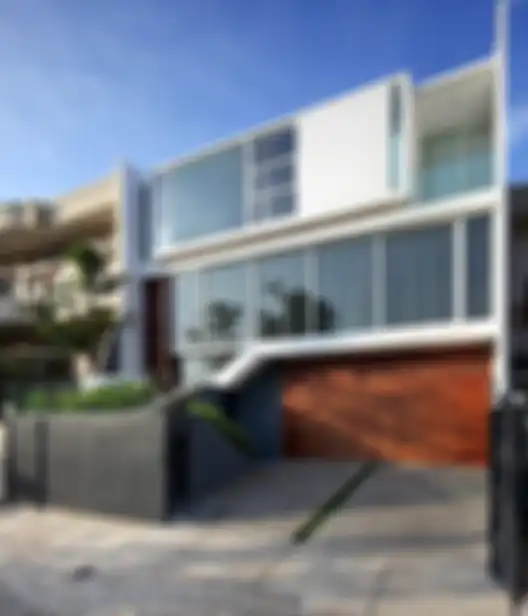 Fasad rumah minimalis modern dengan paduan material dan bentuk simpel geometris.