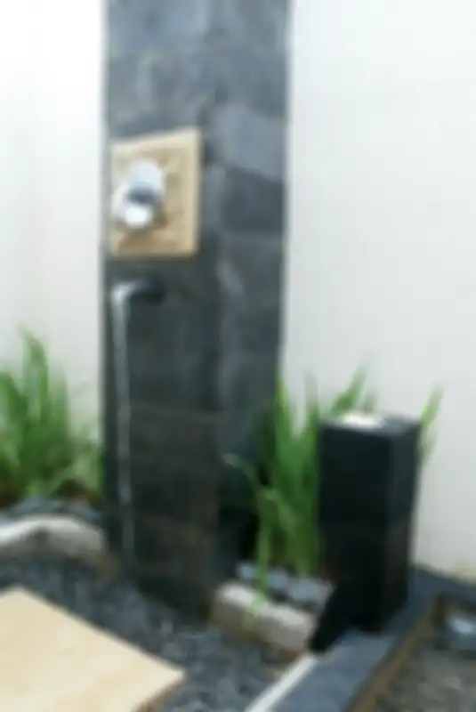Bagian bawahnya dibuat dari batu paras yang diberi koral hitam di sekelilingnya. Kalau ingin lebih natural, batu bisa diganti dengan bilah-bilah kayu bangkirai.
