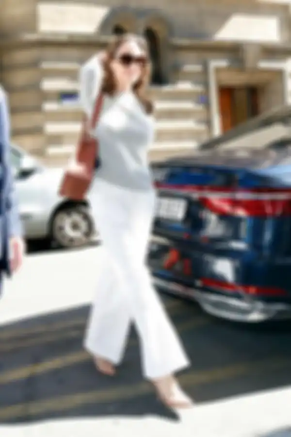 Gaya Angelina Jolie dengan sweater abu-abu dan trousers pants putih. 