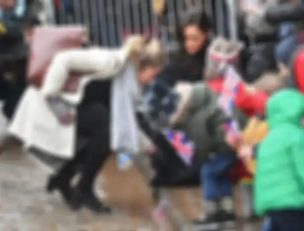 Meghan Markle menyapa anak kecil.