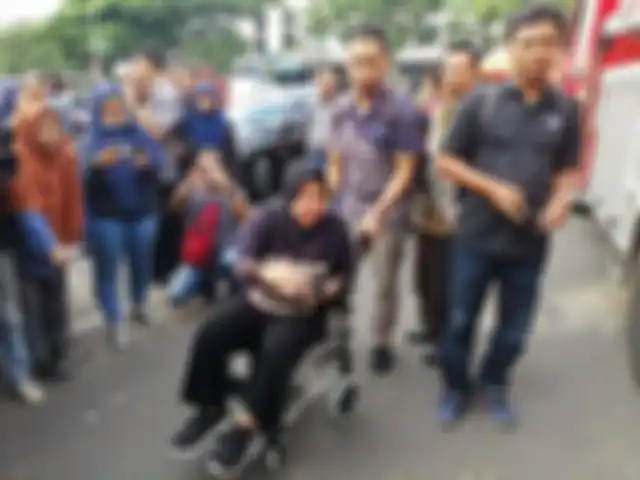 Wali Kota Surbaya, Tri Rismaharini, terlihat menaiki kursi roda dan dibantu oleh ajudan memimpin recovery Jalan Gubeng yang ambles