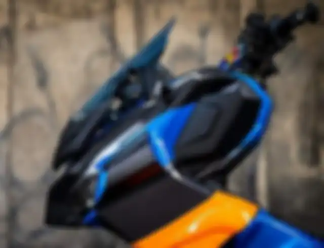 Warna kombinasi hitam, biru, dan oranye disematkan pada body Honda ADV 150 ini.