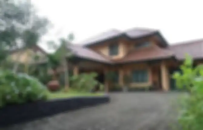 Foto rumah mewah Ikang Fawzi dan Marissa Haque yang mirip resort. Bagian depan rumah memiliki konsep tanpa pagar.