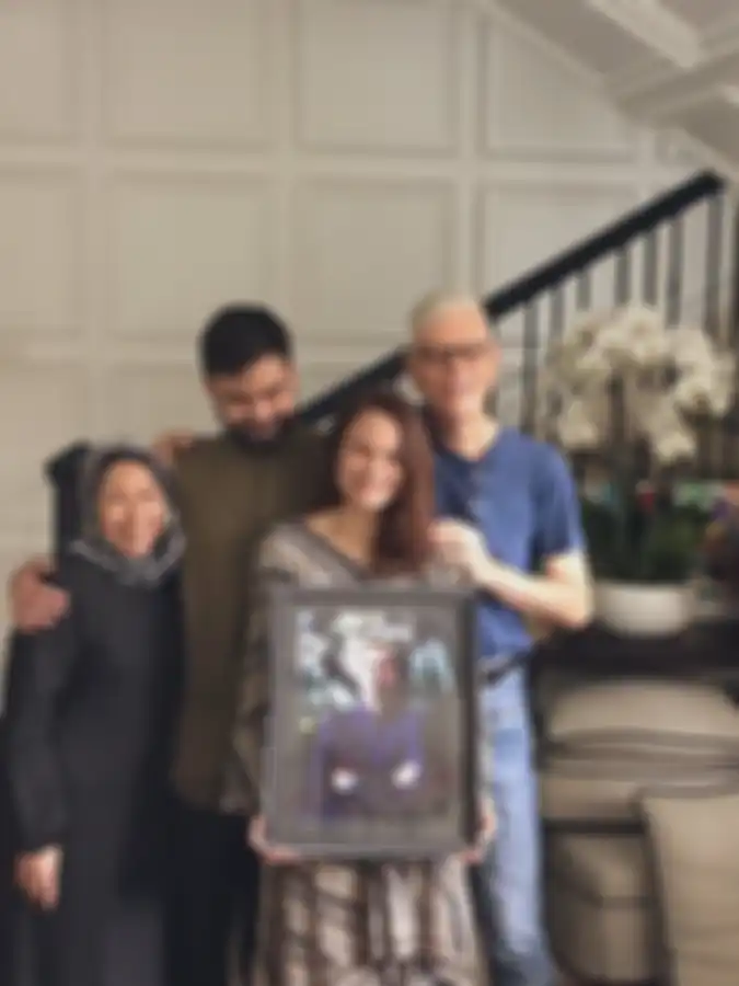 Keluarga Ashraf Sinclair tersenyum sambil membawa fotonya