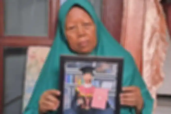 Ibu Iroh menunjukkan foto anaknya Aprih Priyono yang meninggal dunia dipatuk bayi ular King Kobra.