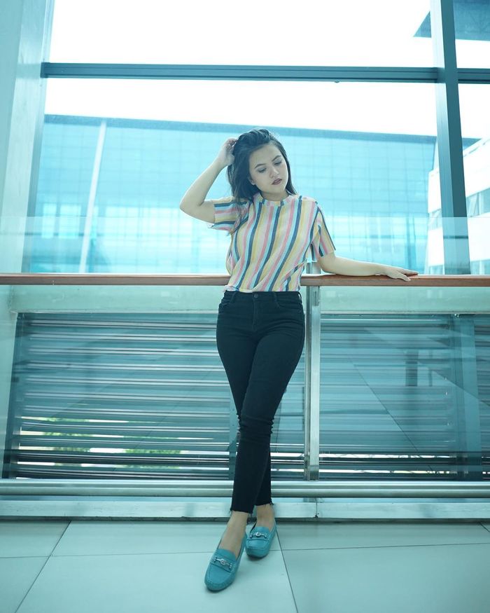 Marsha Aruan tampil dengan blouse bermotif garis vertikal.