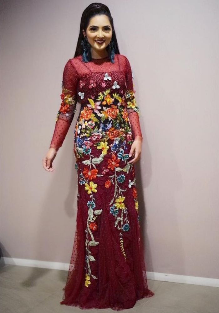 Ashanty tampil dalam balutan sheer dress dengan aksen embellishment floral berwarna merah yang menawan
