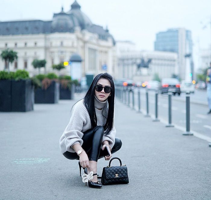 Syahrini tampak mengenakan turtle neck sweater berwarna abu-abu, yang dipadukan dengan skinny pants berbahan lateks