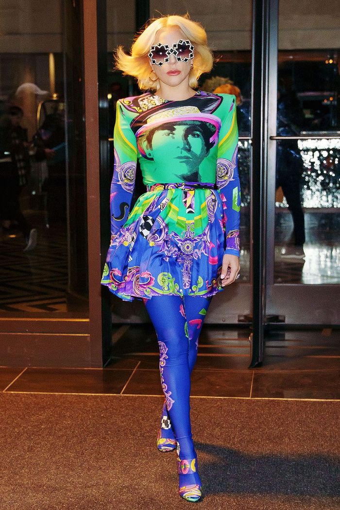 Lady Gaga tampak mengenakan mini dress colorful, dan sunglasses berbentuk unik