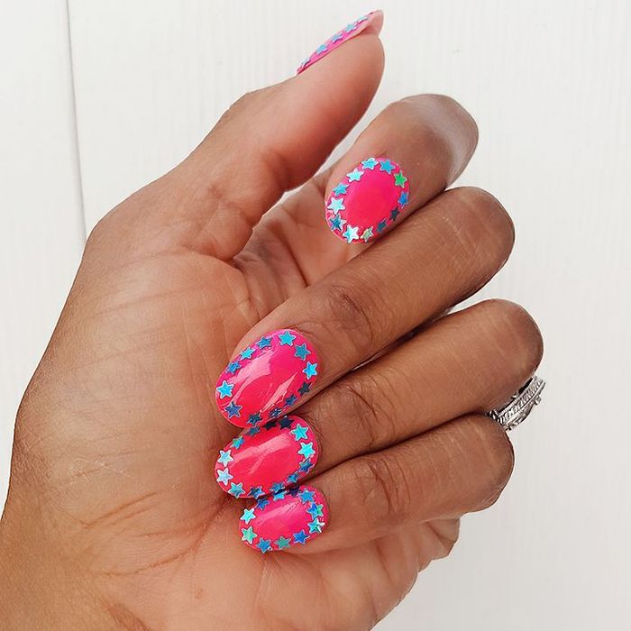 Warna kuteks pink dihiasi dengan detail bintang silver