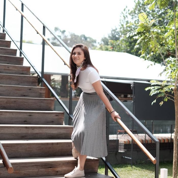 Wulan Guritno dengan t-shirt polos serta rok plisket