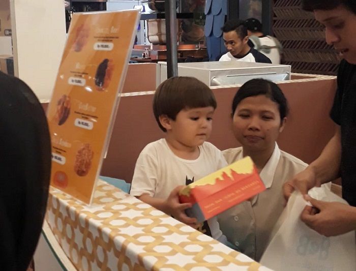 El Barack menyiapkan pesanan pembeli dibantu oleh baby sitter dan seorang asisten.