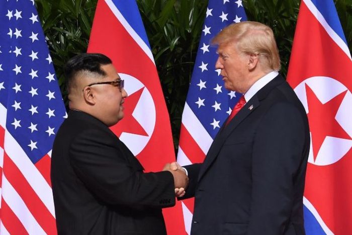 Kim Jong Un dan Donald Trump saling berjabat tangan 