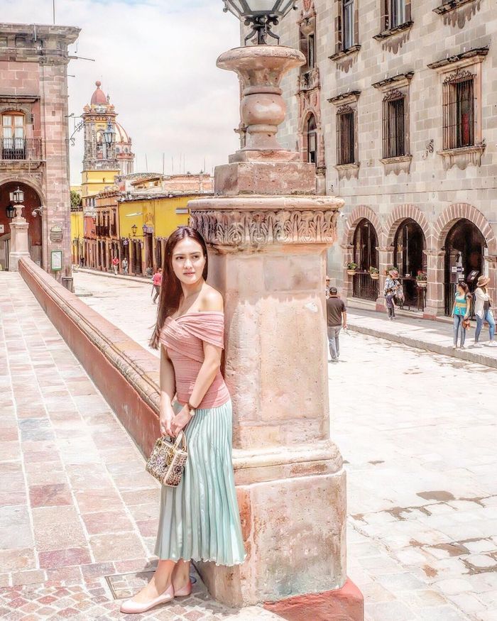 Shandy Aulia memadukan rok plisket dengan atasan nuansa pastel 