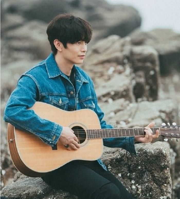 Lee Min Ki sedang memainkan gitar.