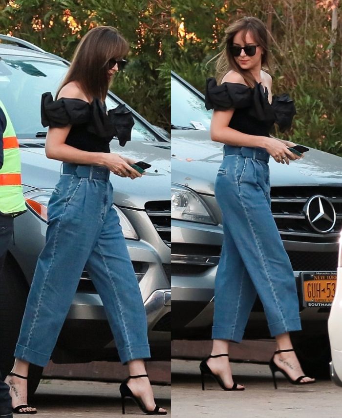 Dakota Johnson mengenakan celana baggy jeans yang ditambah dengan belt yang lebar di bagian pinggangnya