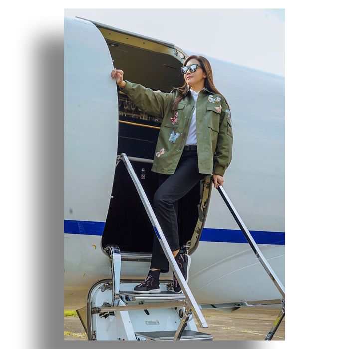 Maia Estianty tampil memadukan kemeja putih polos dengan parka berwarna hijau army