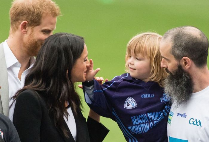 Wajah Meghan Markle dipegang seorang bocah