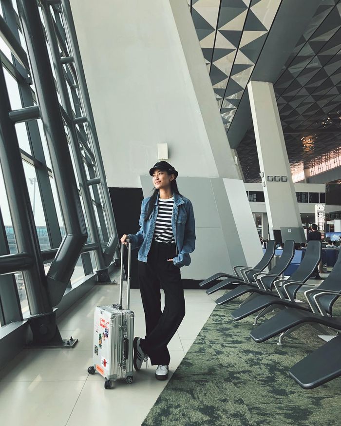 Alika Islamadina tampak bergaya monokrom dengan t-shirt motif stripe yang dipadukan dengan wide leg pants berwarna hitam