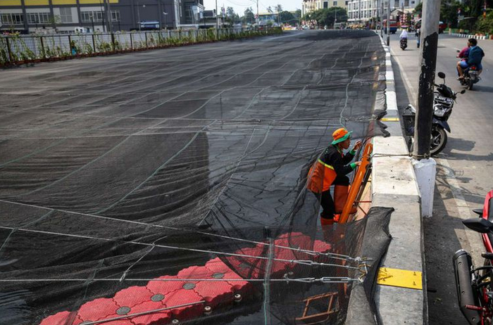 Waring hitam dipasang untuk menutup Kali Item.