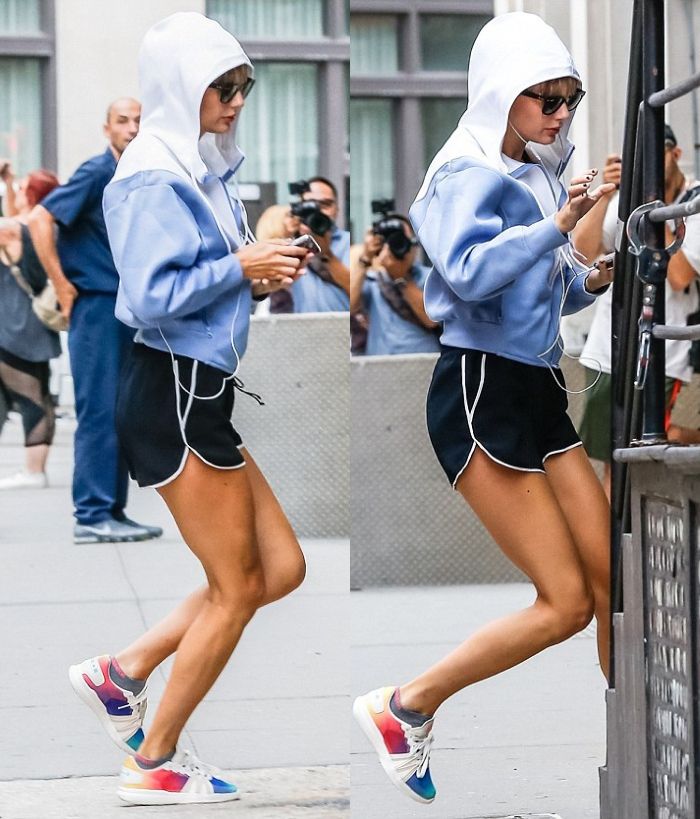 Taylor Swift memilih jaket berwarna kombinasi putih dan juga abu-abu