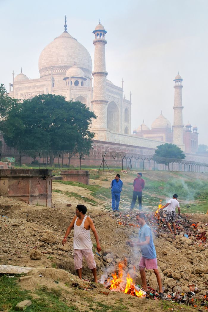 Penduduk lokal membakar sampah di pinggir sungai Yamuna yang dekat dengan Taj Mahal.