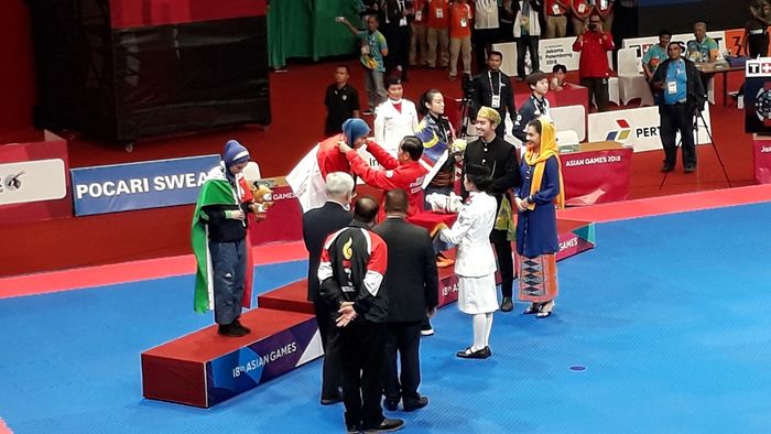 Presiden Joko Widodo mengalungkan langsung emas kepada Defia Rosmaniar, Minggu (19/8/2018).