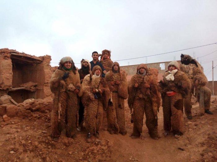 Para lelaki mengenakan kostum dari kulit domba