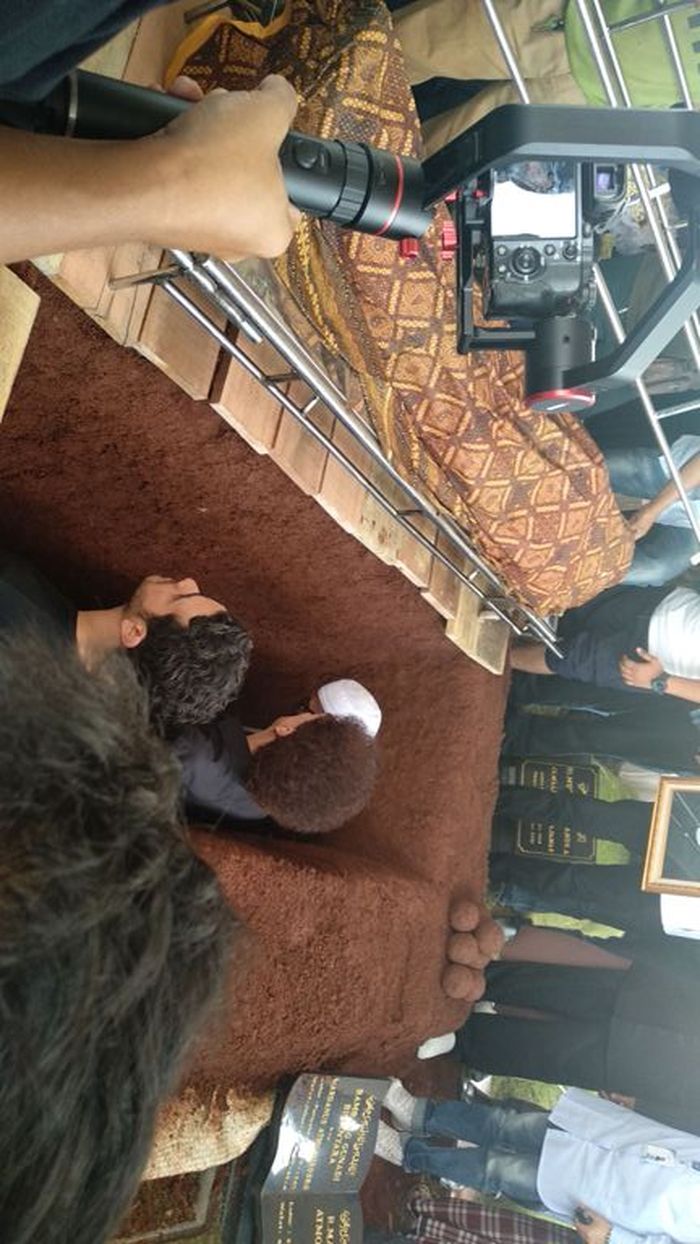 Ahmad Albar dan Fachri Albar memasuki liang lahat Fadly Albar saat proses pemakaman di TPU Tanah Kus