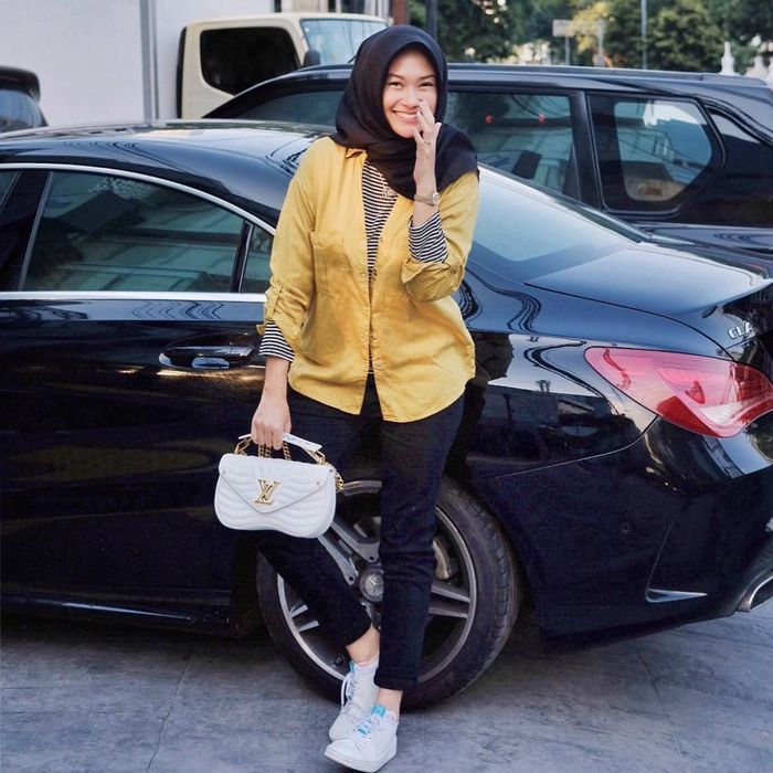 Indah Nada Puspita tampil bergaya kasual dengan dalaman long sleeve t-shirt bermotif stripes, yang d