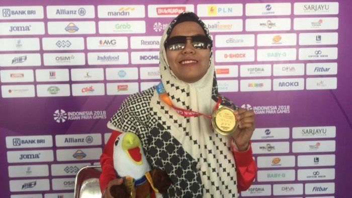 Pecatur tunanetra putri Indonesia, Debi Ariesta saat memamerkan medali emas yang ia dapatkan pada nomor individual standard Asian Para Games di Cempaka Putih, Sport Hall, Jakarta, Rabu (10/10/2018).