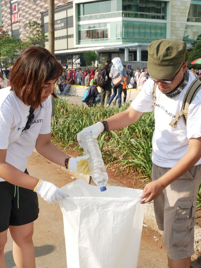 Para peserta #SayaPilihBumi mengumpulkan sampah botol plastik yang tercecer di kawasan MH Thamrin.