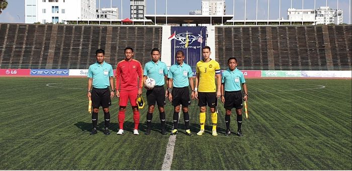 Kapten timnas U-22 Indonesia, Andy Setyo Nugroho, bersama perangkat pertandjngan dan kapten Malaysia, Dominic Tan sebelum laga Piala AFF U-22 2019 di Stadion Nasional, Phnom Penh, Rabu (20/2/2019).