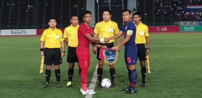 Kapten timnas U-22 Indonesia, Bagas Adi (merah) dan kapten timnas U-22 Thailand, Saringkan Promsupa sali berjabat tangan sebelum final Piala AFF U-22 2019, 26 Februari 2019.