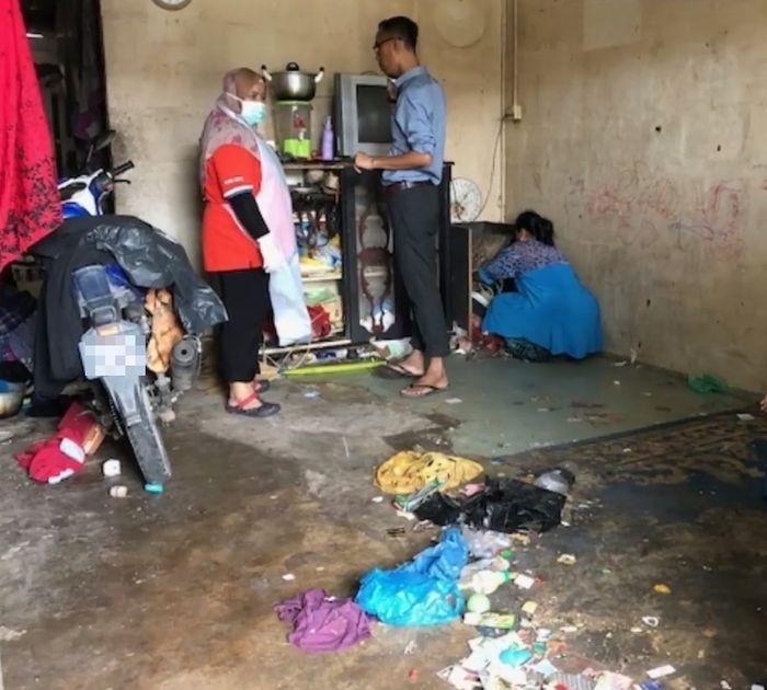 Warga membantu membersihkan rumah Sariah Ahmad yang penuh sampah