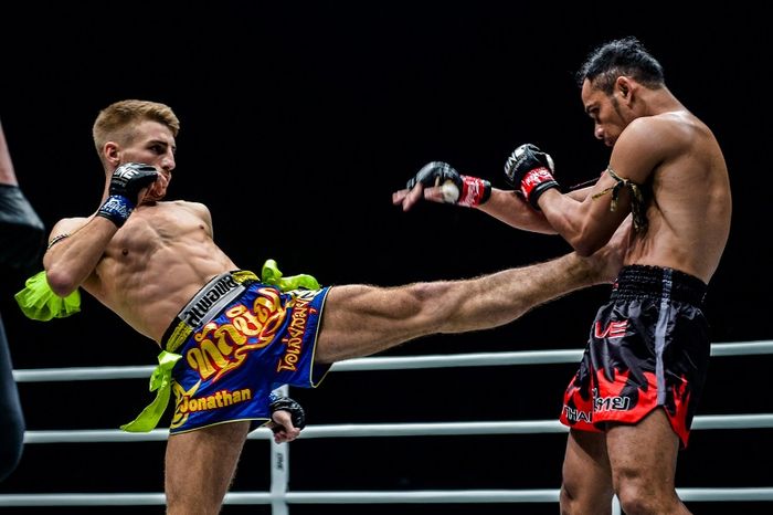 Petarung asal Inggris, Jonathan Haggerty (kiri), melepaskan tendangan ke arah juara dunia ONE Flyweight Muay Thai, Sam-A Gaiyanghadao, dalam ONE: For Honor di Istora Senayan, Jumat (3/5/2019).