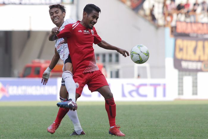 Pemain Persija Jakarta, Ramdani Lestaluhu berebut bola dengan pemain Bali United, Fadil pada Kratingdaeng Piala Indonesia di Stadion Wibawa Mukti, Cikarang, Jawa Barat, Minggu (5/4/2019) dalam laga tersebut persija menang melawan Bali United dengan skor 1-0