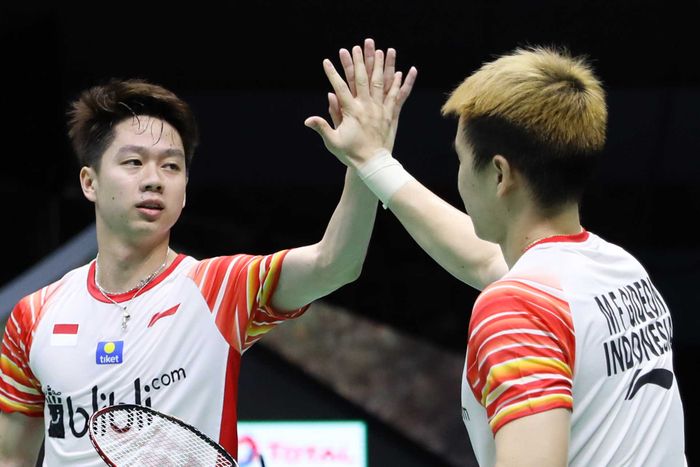 Pasangan ganda putra Indonesia, Marcus Fernaldi Gideon/Kevin Sanjaya Sukamuljo, melakukan tos seusai memenangi pertandingan melawan Marcus Ellis/Chris Langridge pada penyisihan Grup B Piala Sudirman 2019 kontra Inggris di Guangxi Sports Center Gymnasium, Nanning, China, Minggu (19/5/2019).