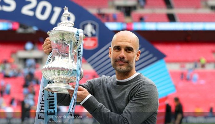 Pelatih Manchester City, Pep Guardiola, bersama trofi Piala FA musim 2018-2019.