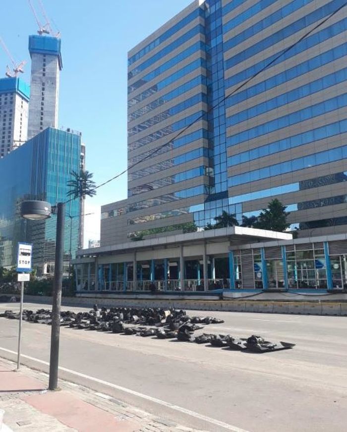 Sejumlah aparat kepolisian dan TNI beristirahat sambil berjaga-jaga di Halte Trans Jakarta, Sarinah.