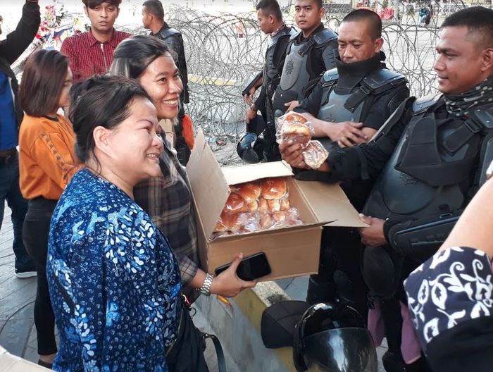 Polri menerima pemberian roti dari warga sebagai bentuk terima kasih.