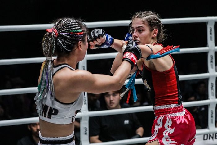 Atlet ONE Championship asal Thailand, Stamp Fairtex (kiri), mendapat pukulan dari petarung asal Australia, Alma Juniku, dalam ajang ONE: Legendary Quest di Shanghai, China.