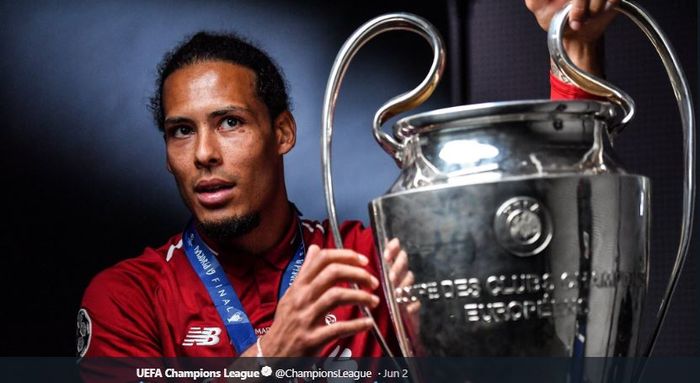 Bek Liverpool FC, Virgil van Dijk, memegang trofi Liga Champions. 