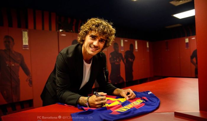 Antoine Griezmann menandatangani seragam anyarnya di FC Barcelona.