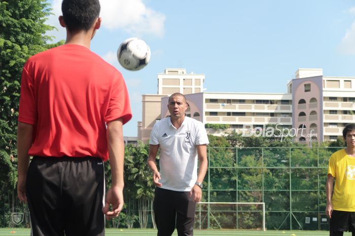 Legenda Juventus, David Trezeguet, melemparkan operan ke salah seorang pemain dari acara Singapore Legacy Project yang diselenggarakan oleh International Champions Cup 2019 di Bendemeer Secondary School, Sabtu (20/7/2019).