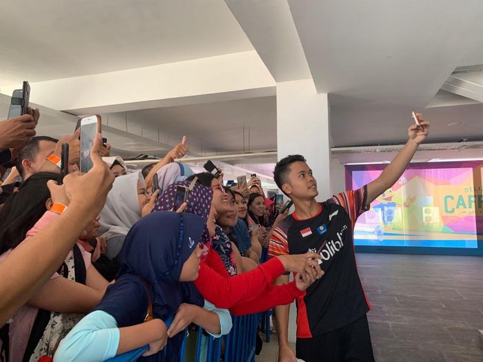 Pebulu tangkis tunggal putra Indonesia, Anthony Sinisuka Ginting, melakukan swafoto bersama para penggemarnya di area media center Indonesia Open 2019 di Istora Senayan, Jakarta.