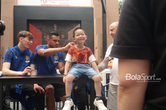 Seorang fan cilik tersipu malu saat mendapat tanda tangan dari para pemain Manchester United saat menghadiri meet and greet International Champions Cup 2019 di Resorts World Sentosa, Minggu (21/7/2019).