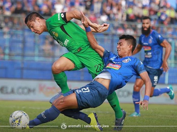 Striker Arema FC, Dedik Setiawan, mendapatkan pengawalan ketat dari bek Bhayangkara FC, Indra Kahfi, pada laga pekan ke-11 Liga 1 2019